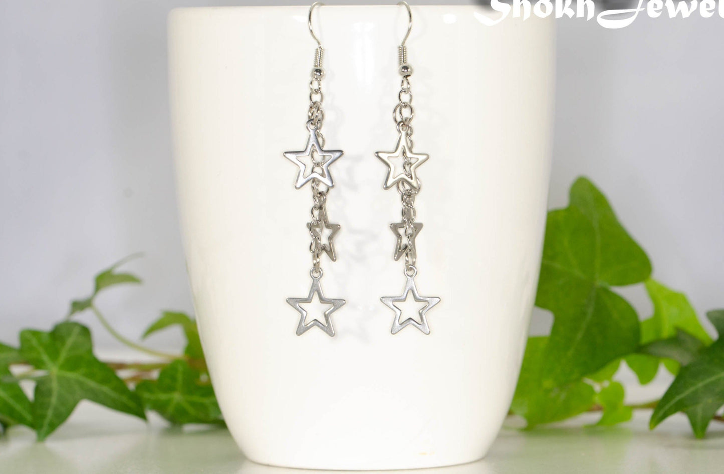 Stainless steel chain and star earrings on a coffee mug