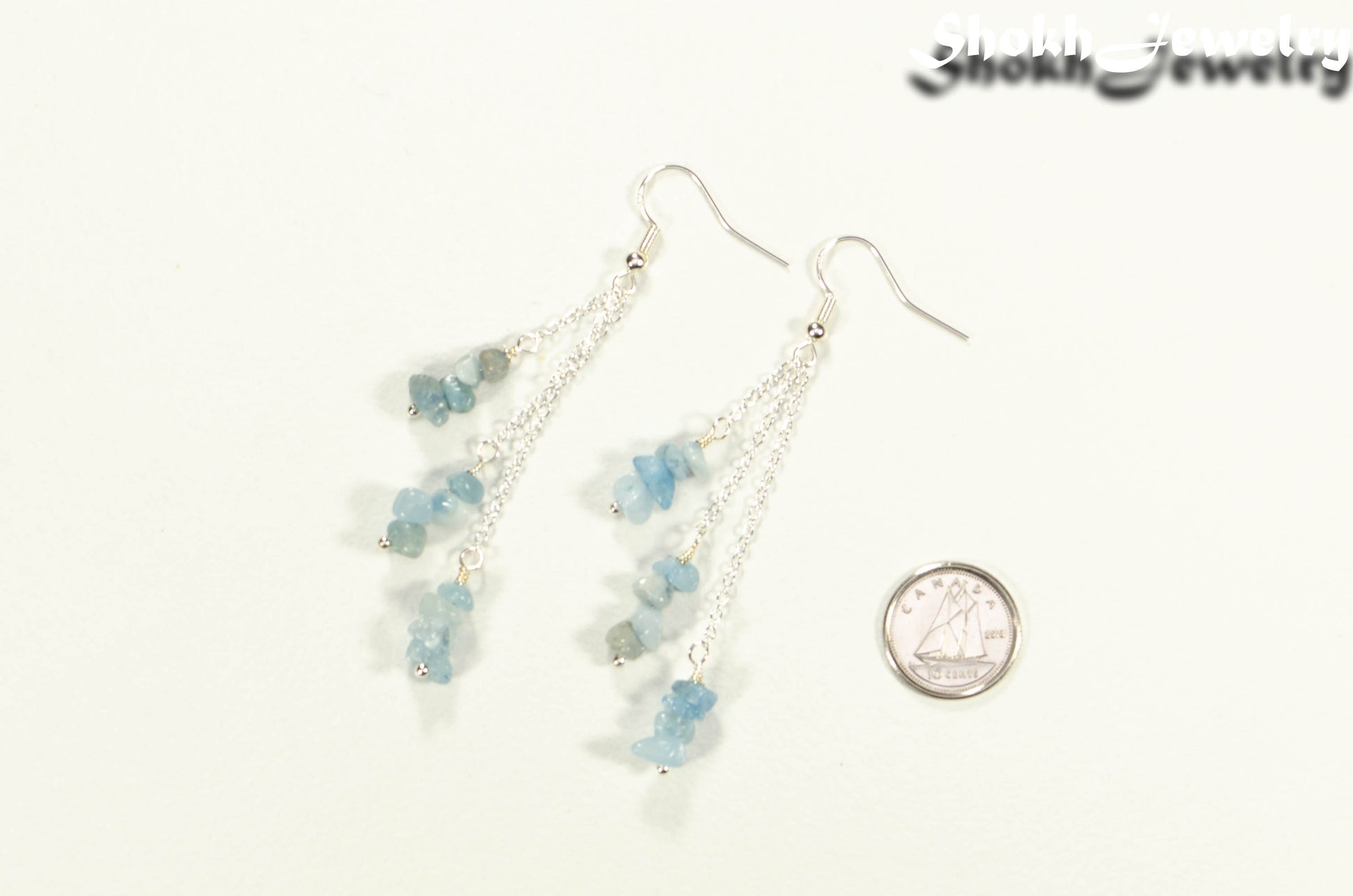 Long Silver Plated Chain and Aquamarine Crystal Chip Earrings beside a dime
