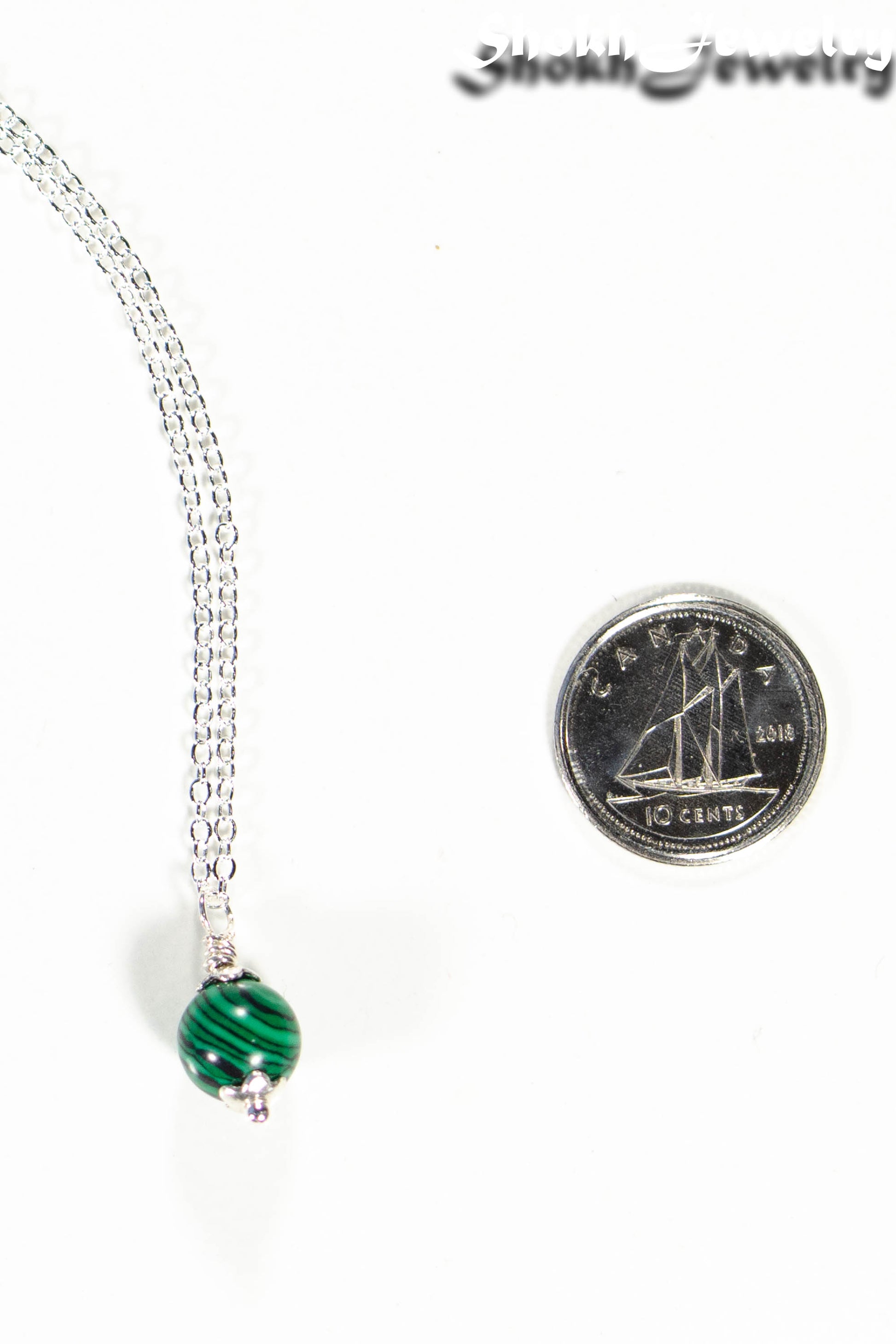 Close up of a Dainty Malachite Choker Necklace beside a dime