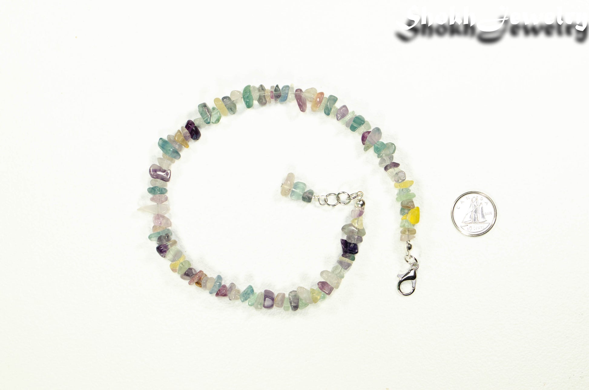 Natural Rainbow Fluorite Crystal Chip Choker Necklace beside a dime