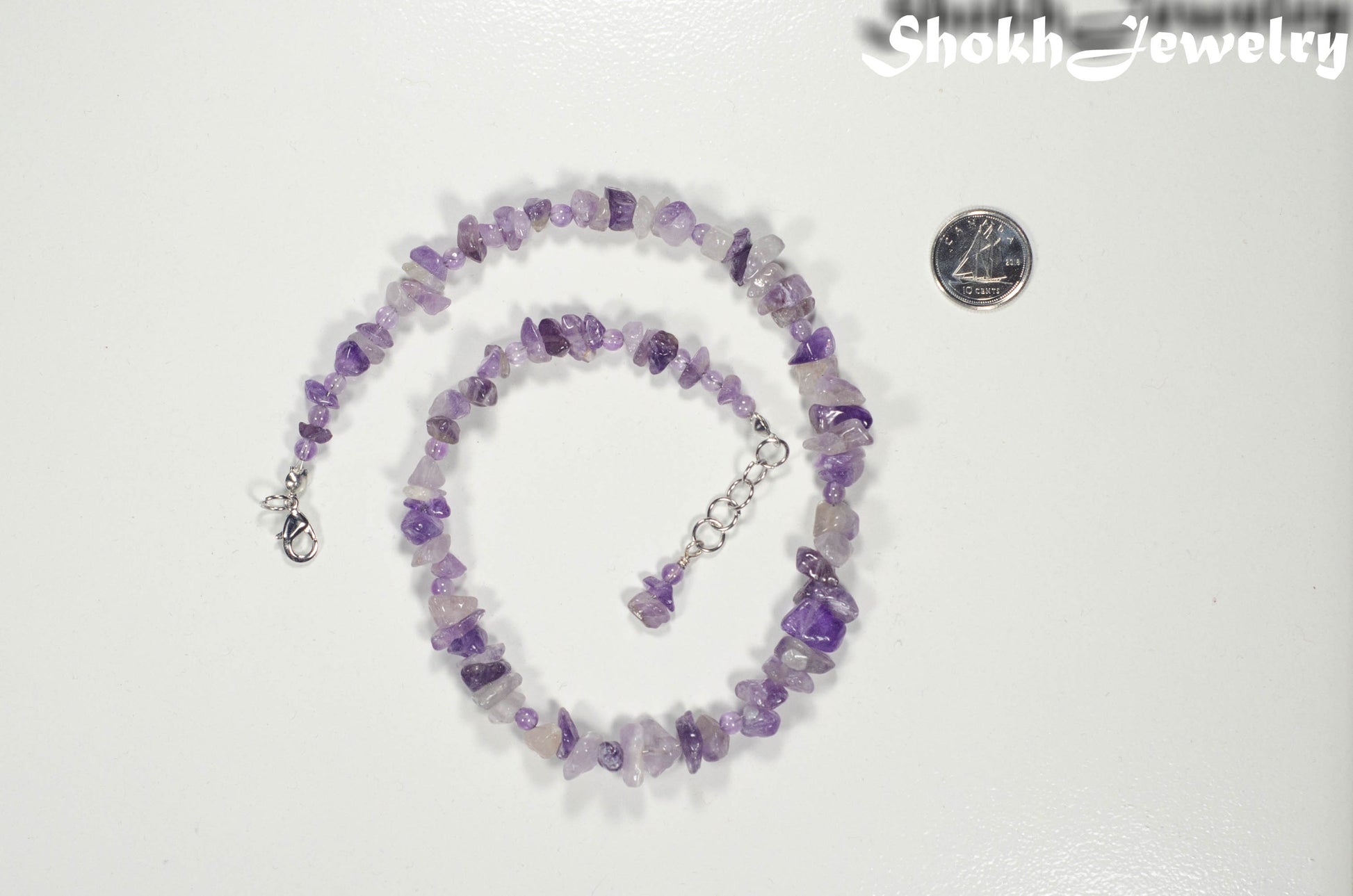 Natural Amethyst Crystal Chip Choker Necklace beside a dime