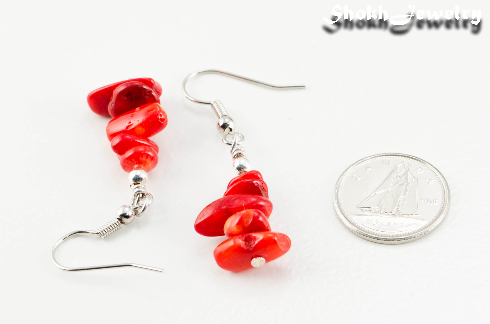 Natural Red Coral Chip Earrings beside a dime