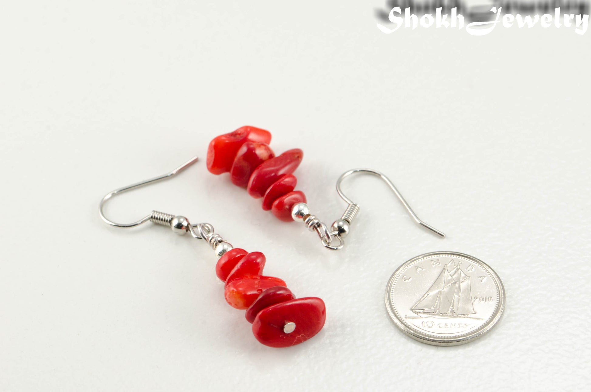 Simple Red Coral Chip Earrings beside a dime.