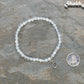 4mm White Opal Bracelet with Initial beside a dime