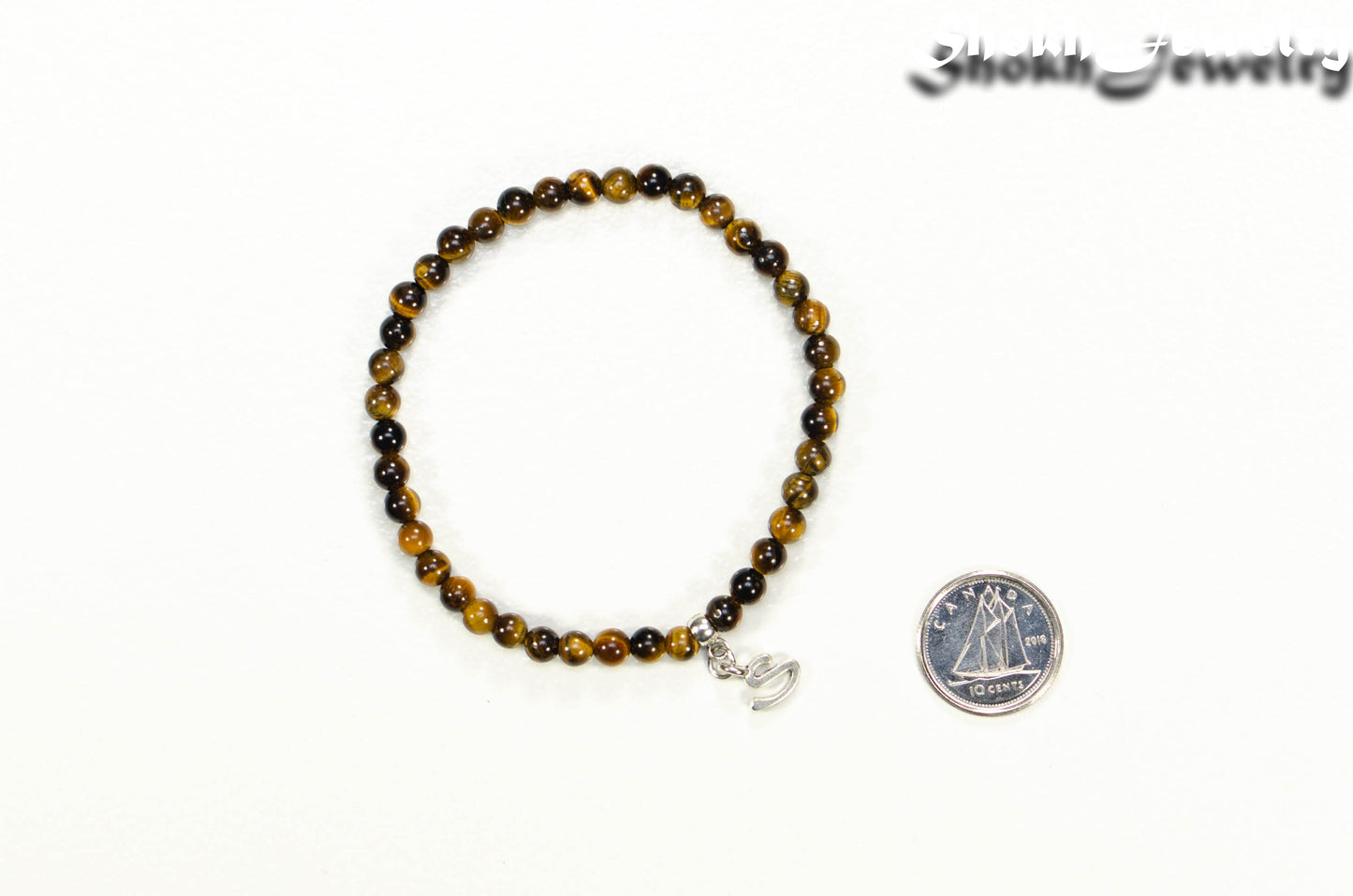 4mm Tiger's Eye Bracelet with Initial beside a dime.