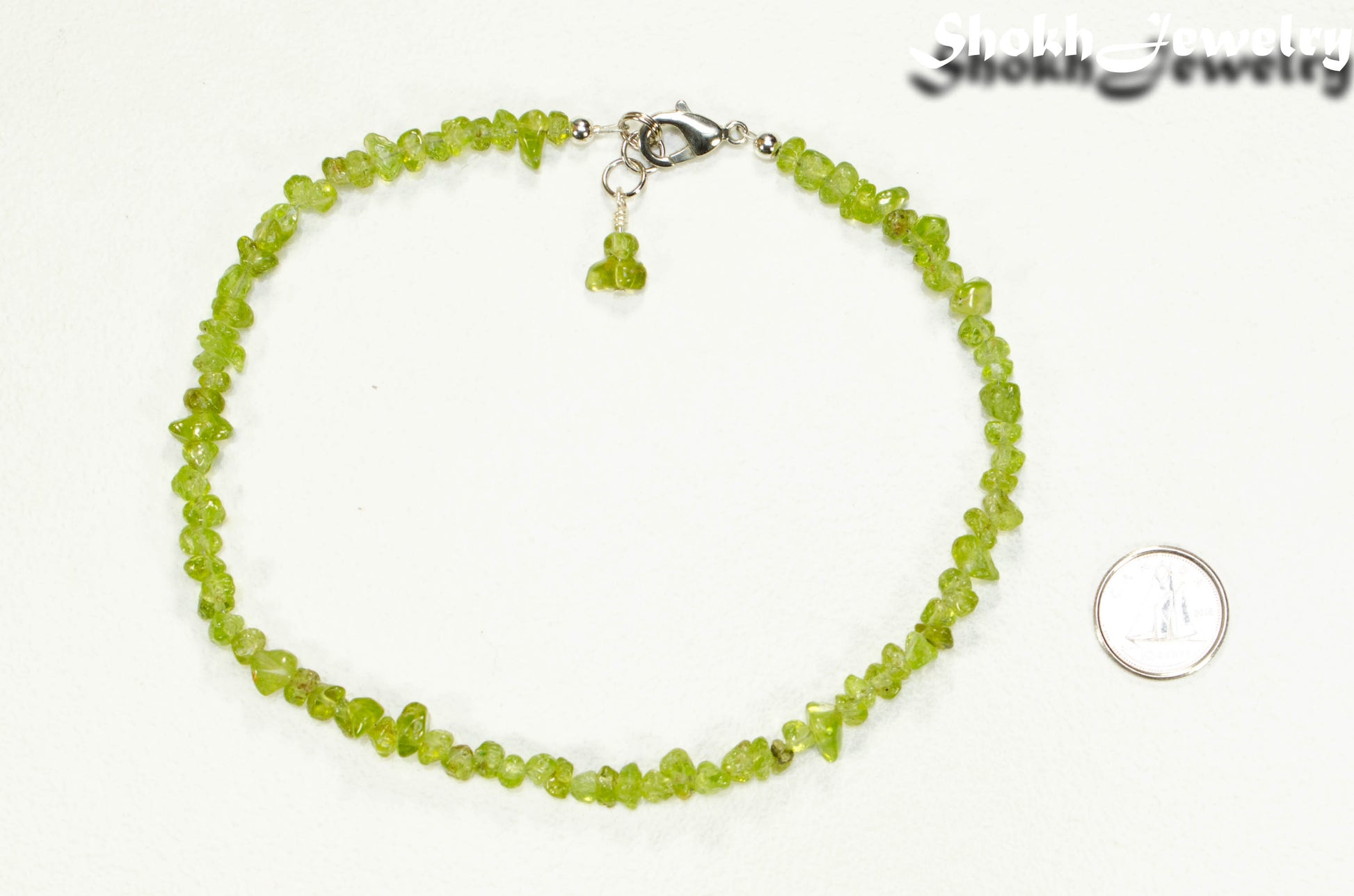 Natural Peridot Crystal Chip Choker Necklace beside a dime