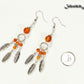 Statement Carnelian Crystal And Feather Earrings beside a dime.