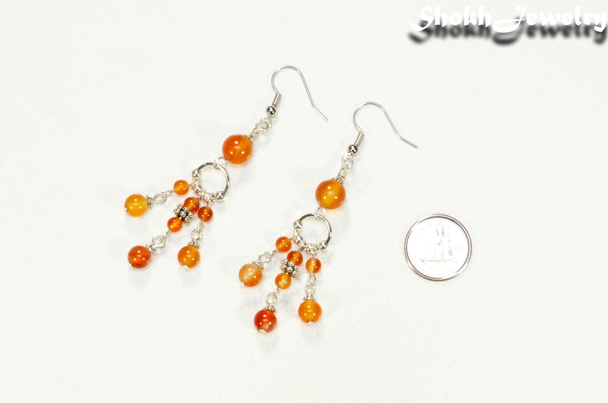 Statement Carnelian Crystal Chandelier Earrings beside a dime.