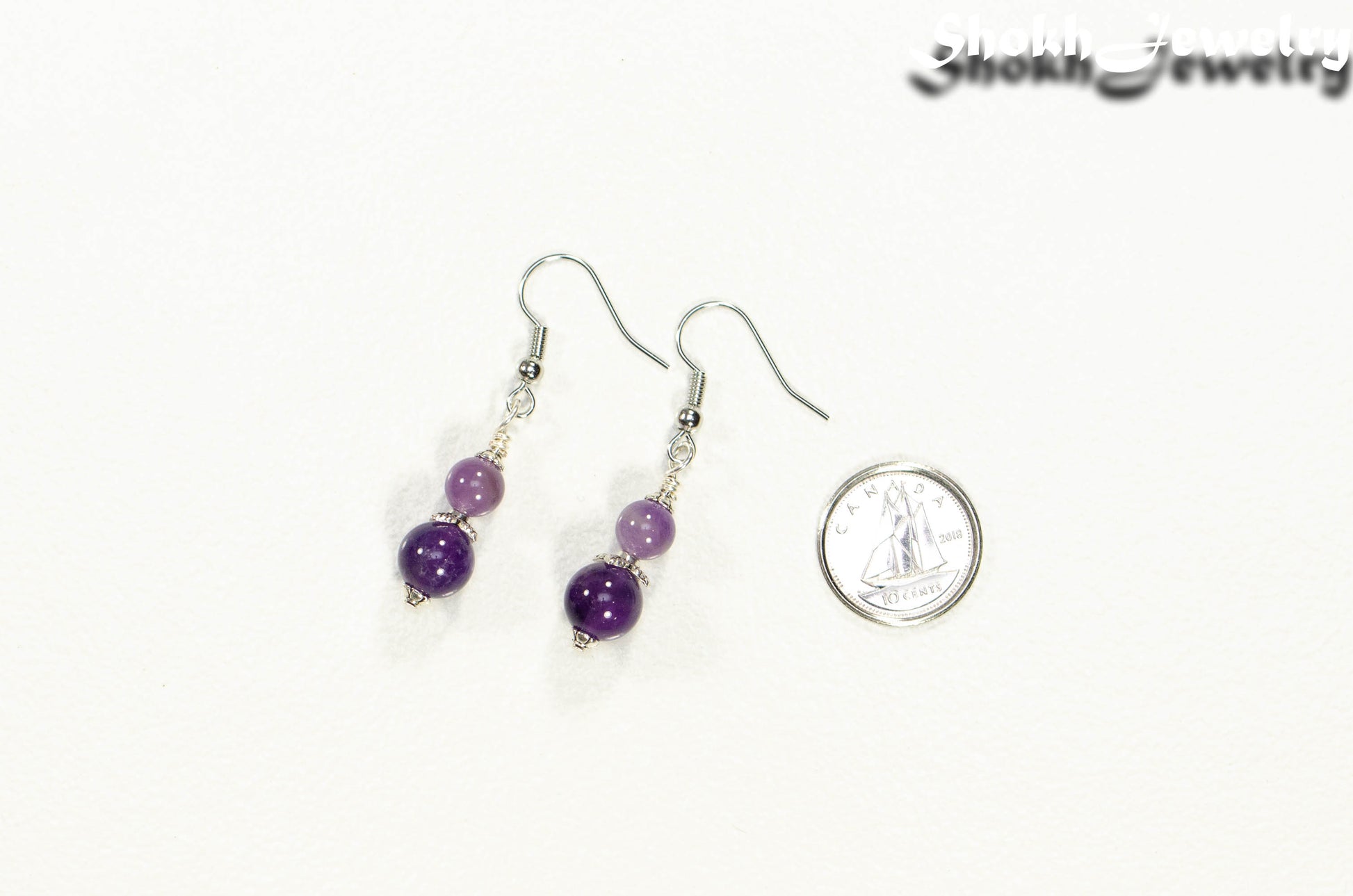 Small Natural Amethyst Crystal Earrings beside a dime