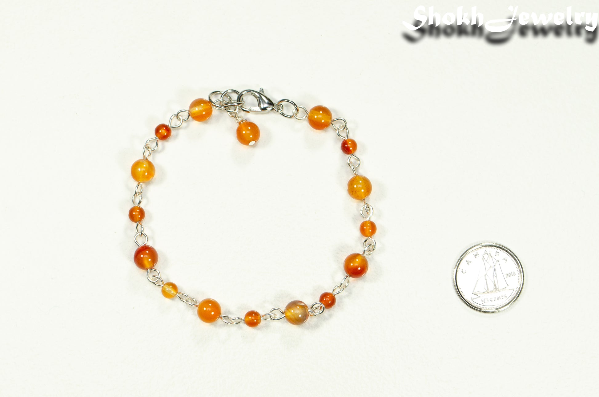 Handmade Carnelian Link Bracelet beside a dime.