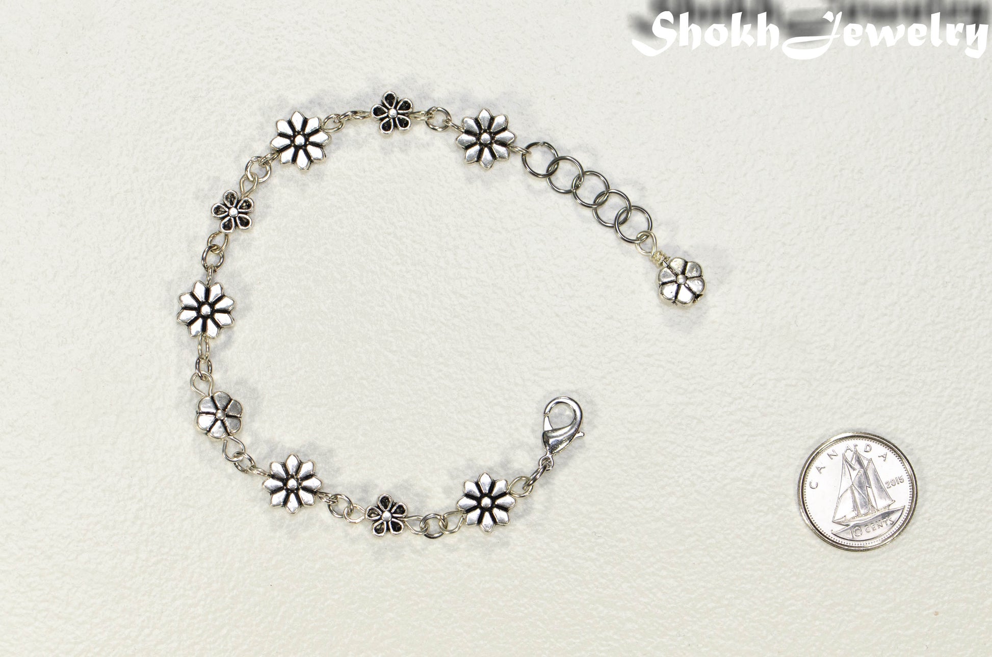 Tibetan silver Flower Bracelet beside a dime.