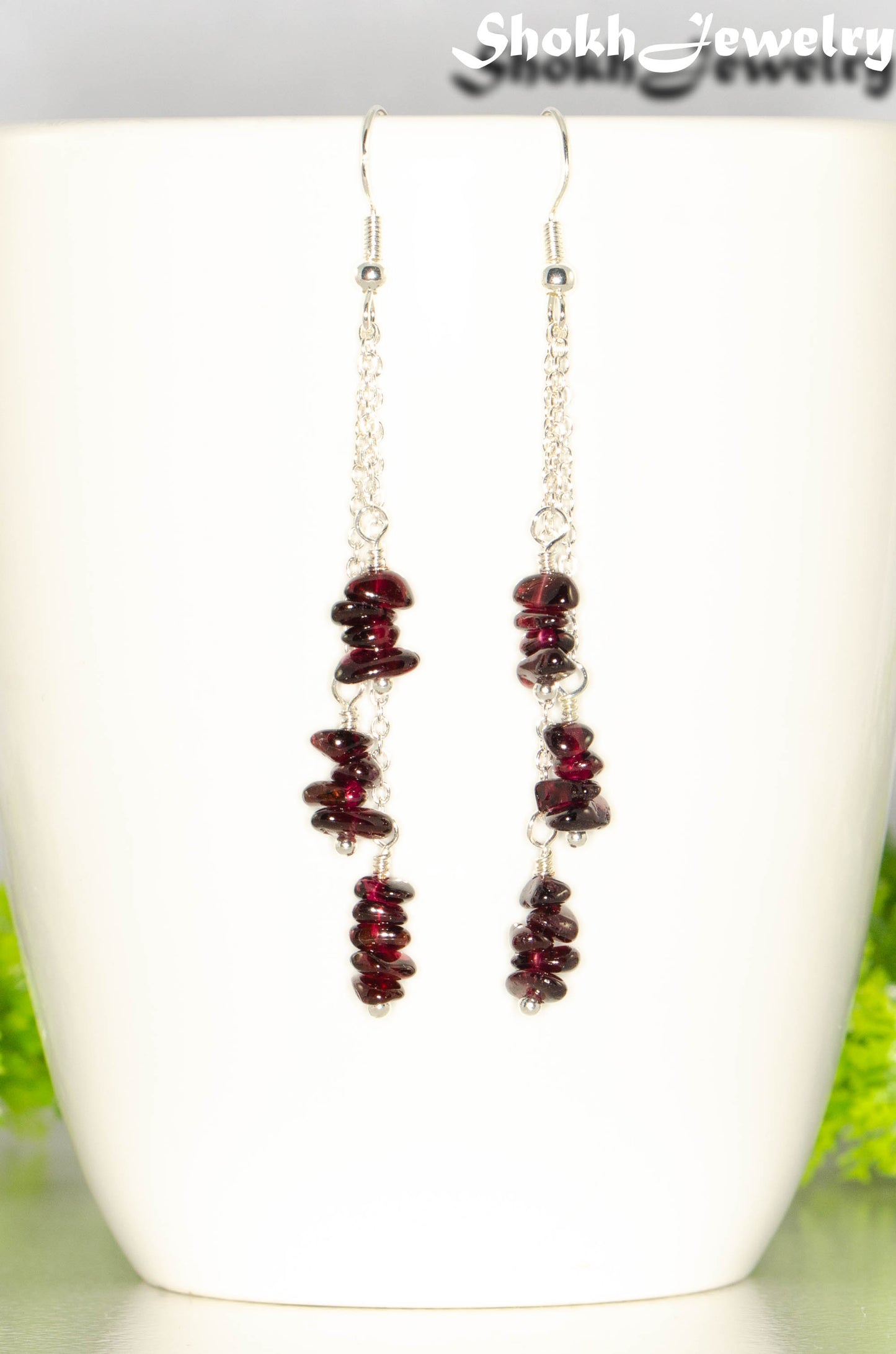 Long Silver Plated Chain and Garnet Crystal Chip Earrings on a mug