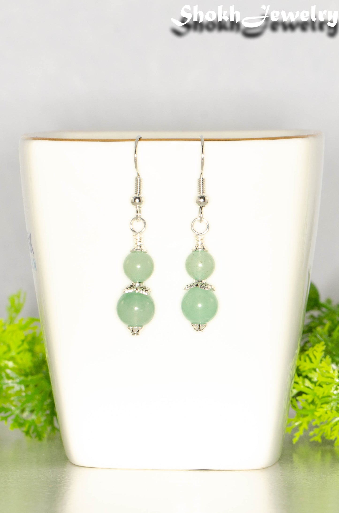 Small Green Aventurine Crystal Earrings on a tea cup