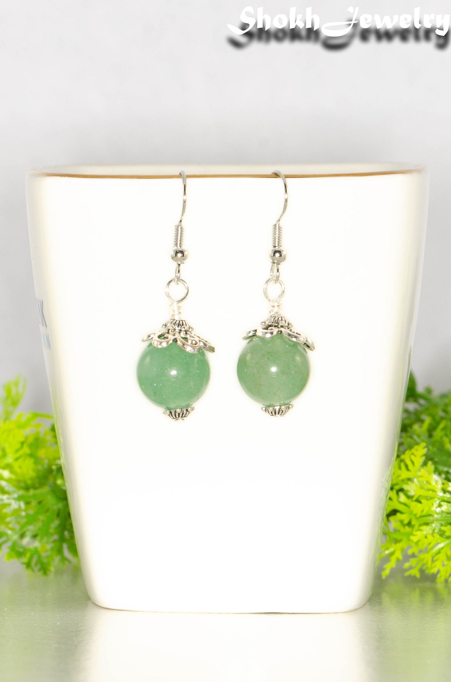 12mm Natural Green Aventurine Crystal Earrings on a tea cup