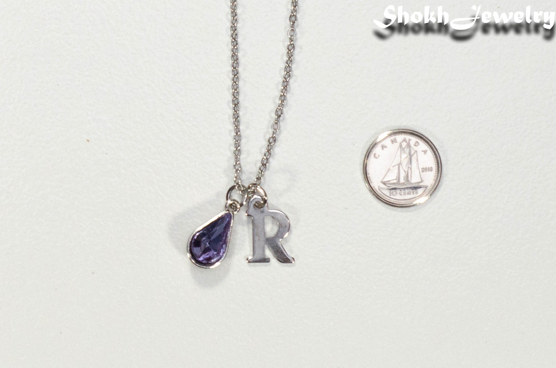 Personalized June Birthstone pendant beside a dime