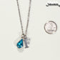 Personalized March Birthstone pendant beside a dime