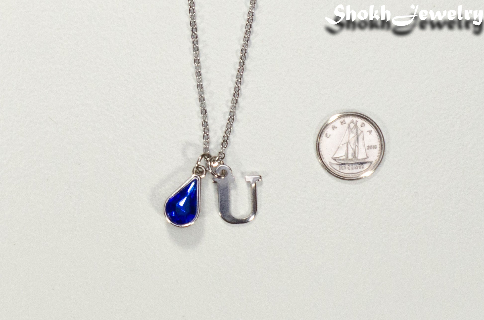 Personalized September Birthstone pendant beside a dime