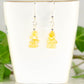 Simple Citrine Crystal Chip Earrings displayed on a tea cup.