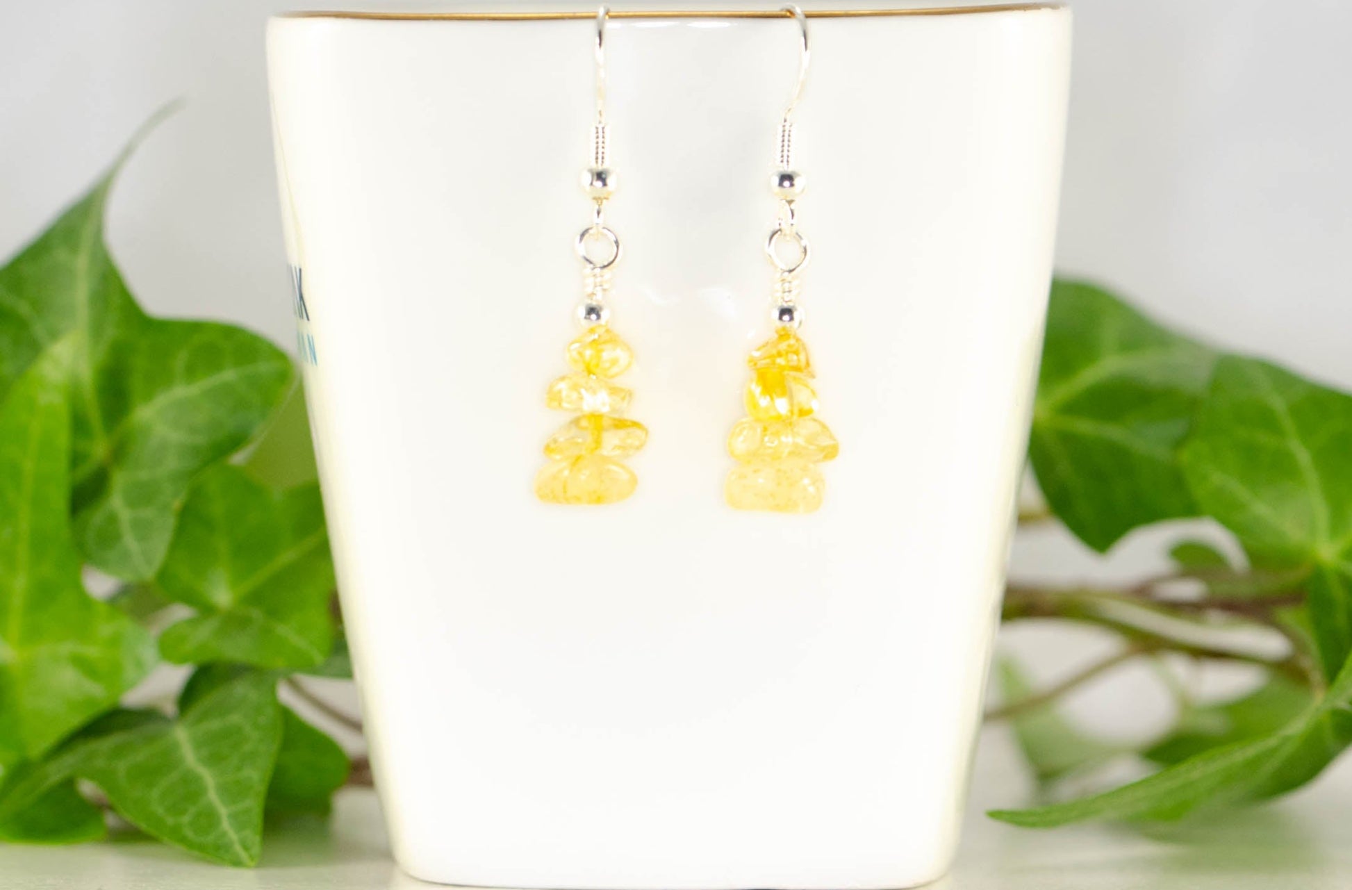 Simple Citrine Crystal Chip Earrings displayed on a tea cup.