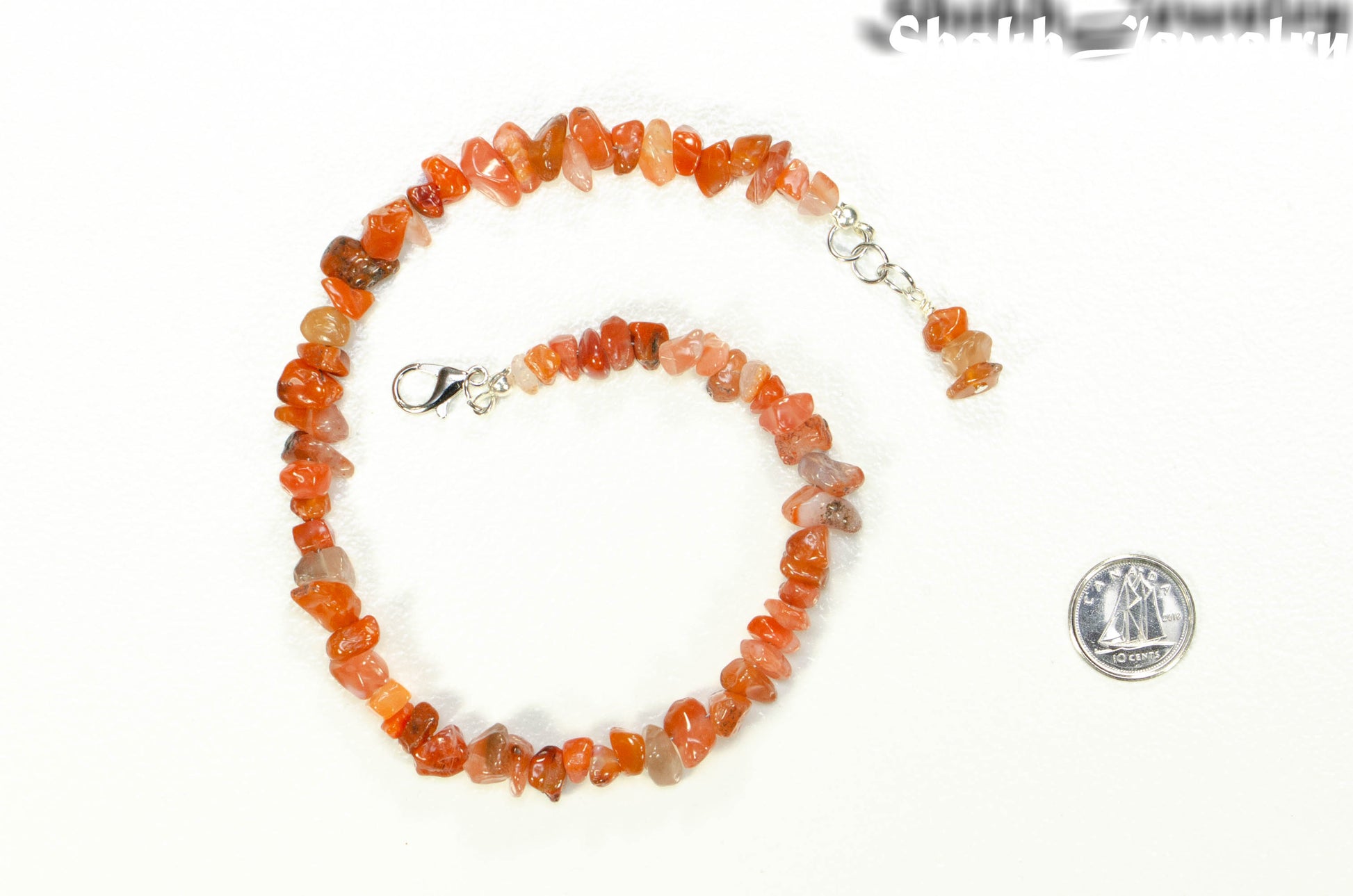 Natural Carnelian Crystal Chip Choker Necklace beside a dime