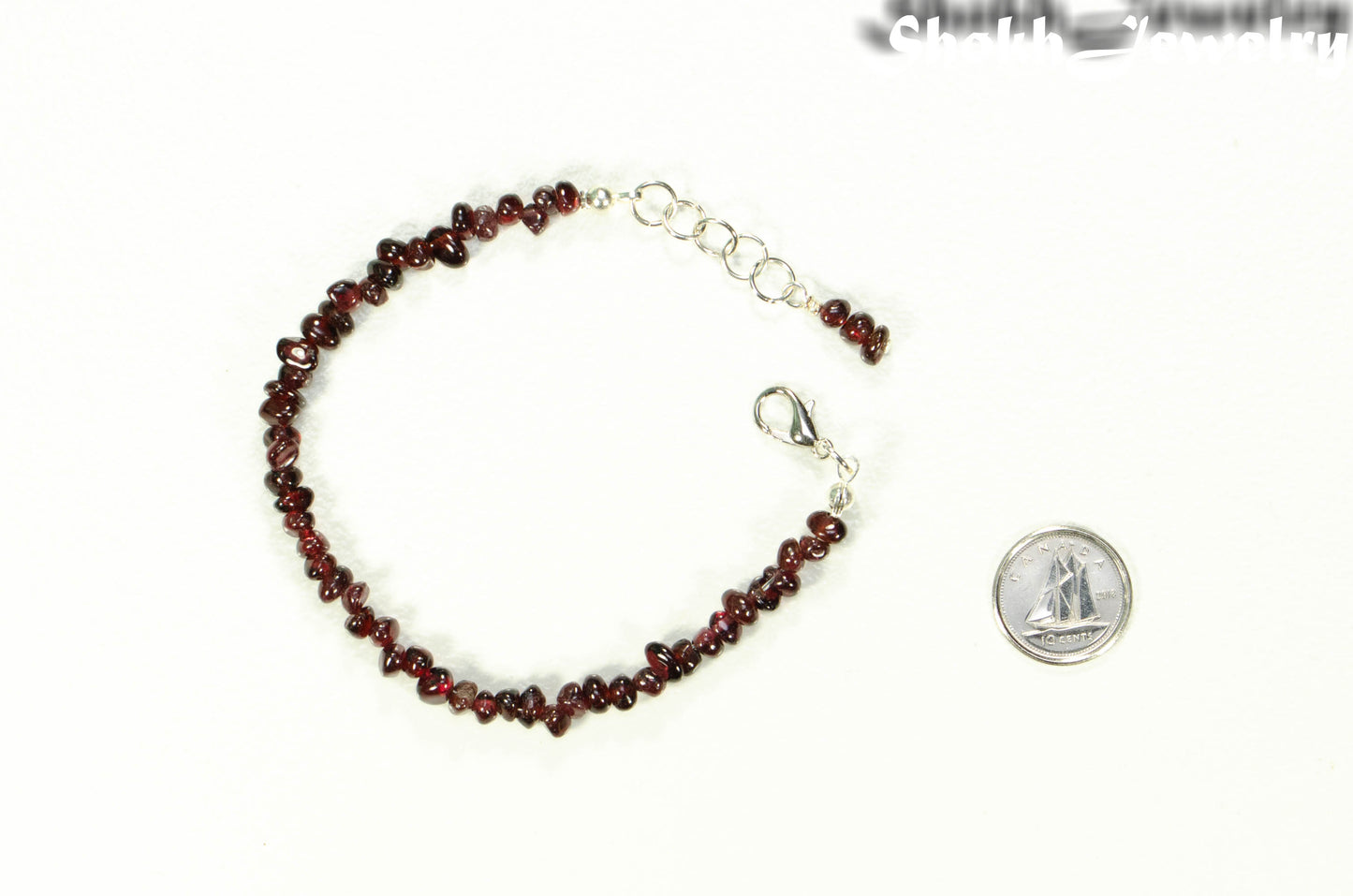 Natural Garnet Crystal Chip Bracelet beside a dime