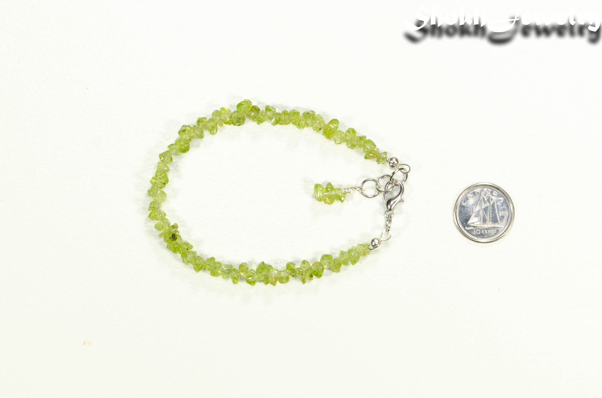 Natural Peridot Crystal Chip Bracelet beside a dime
