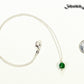 Dainty Emerald Choker Necklace beside a dime