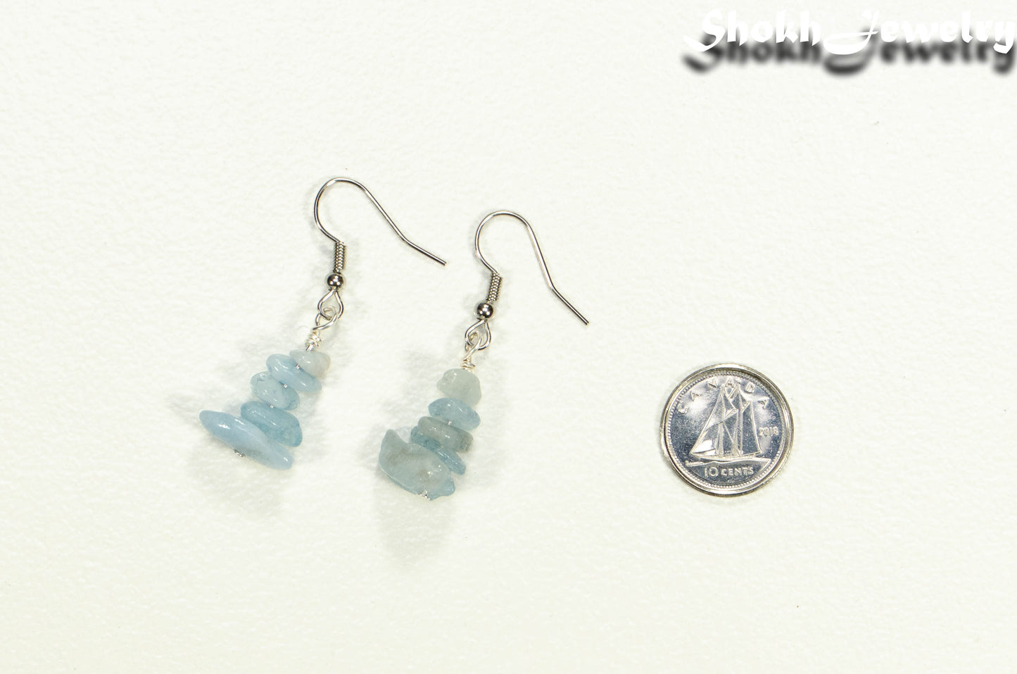 Simple Aquamarine Crystal Chip Earrings beside a dime.