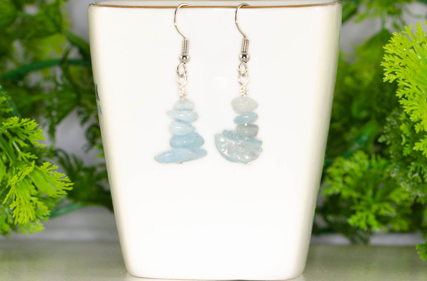 Simple Aquamarine Crystal Chip Earrings displayed on a tea cup.