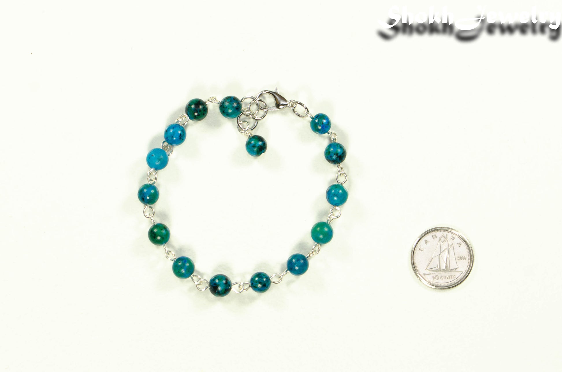 6mm Blue Jade Link Bracelet beside a dime.