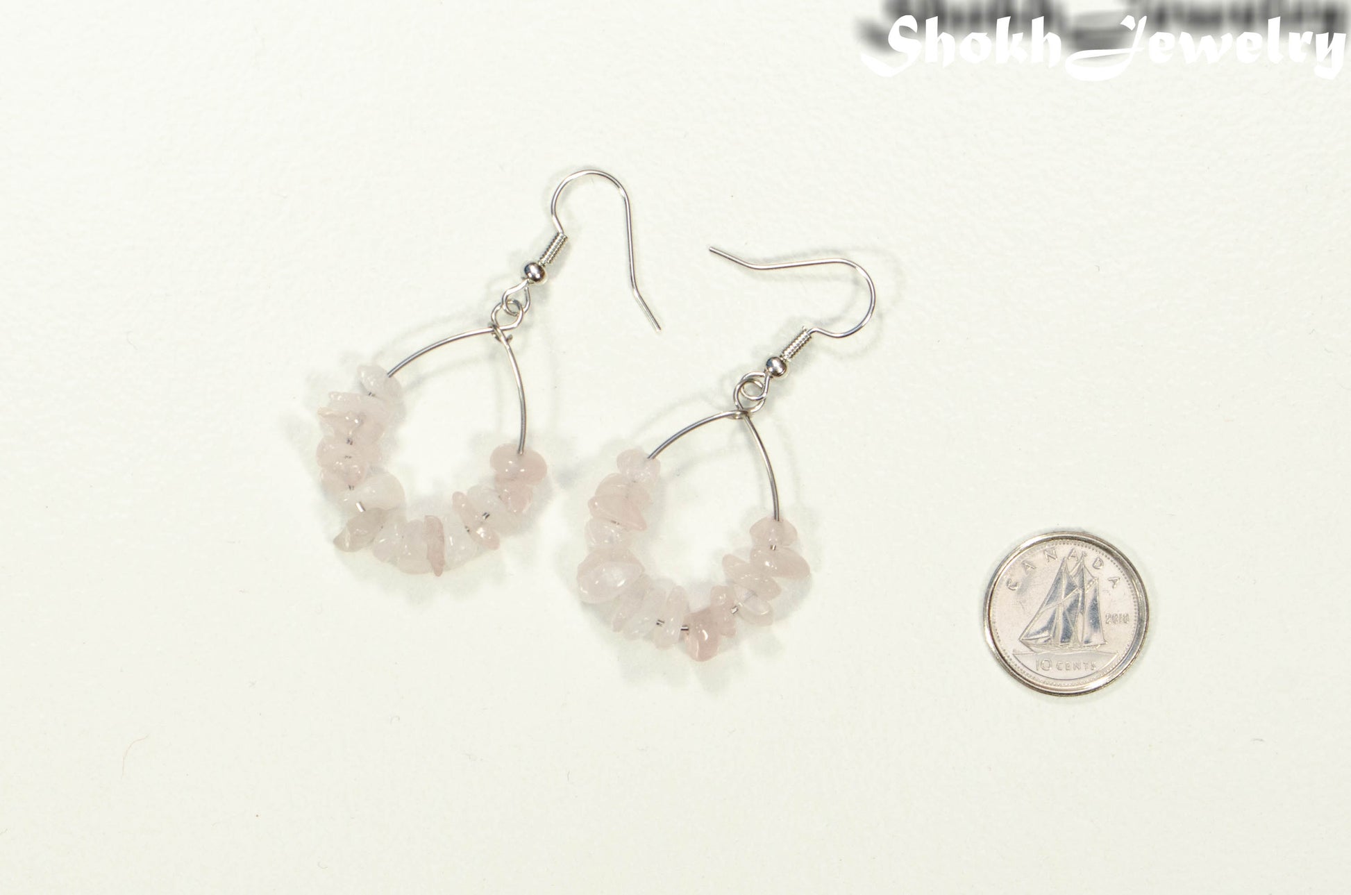 Natural Rose Quartz Crystal Chip Earrings beside a dime