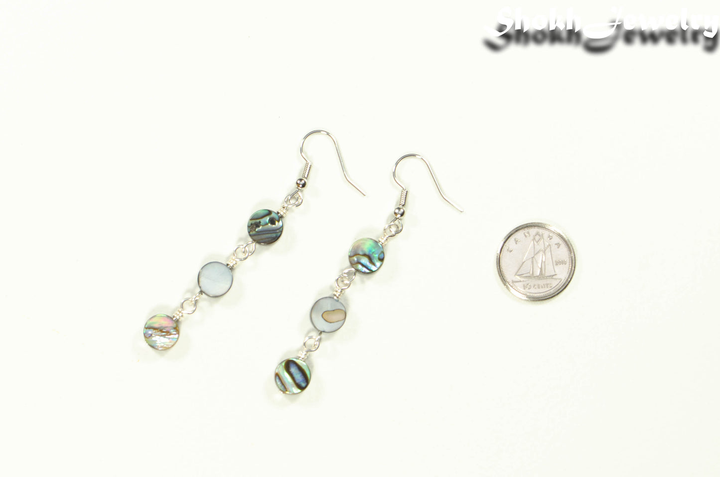 Long Natural Abalone Shell Earrings beside a dime.