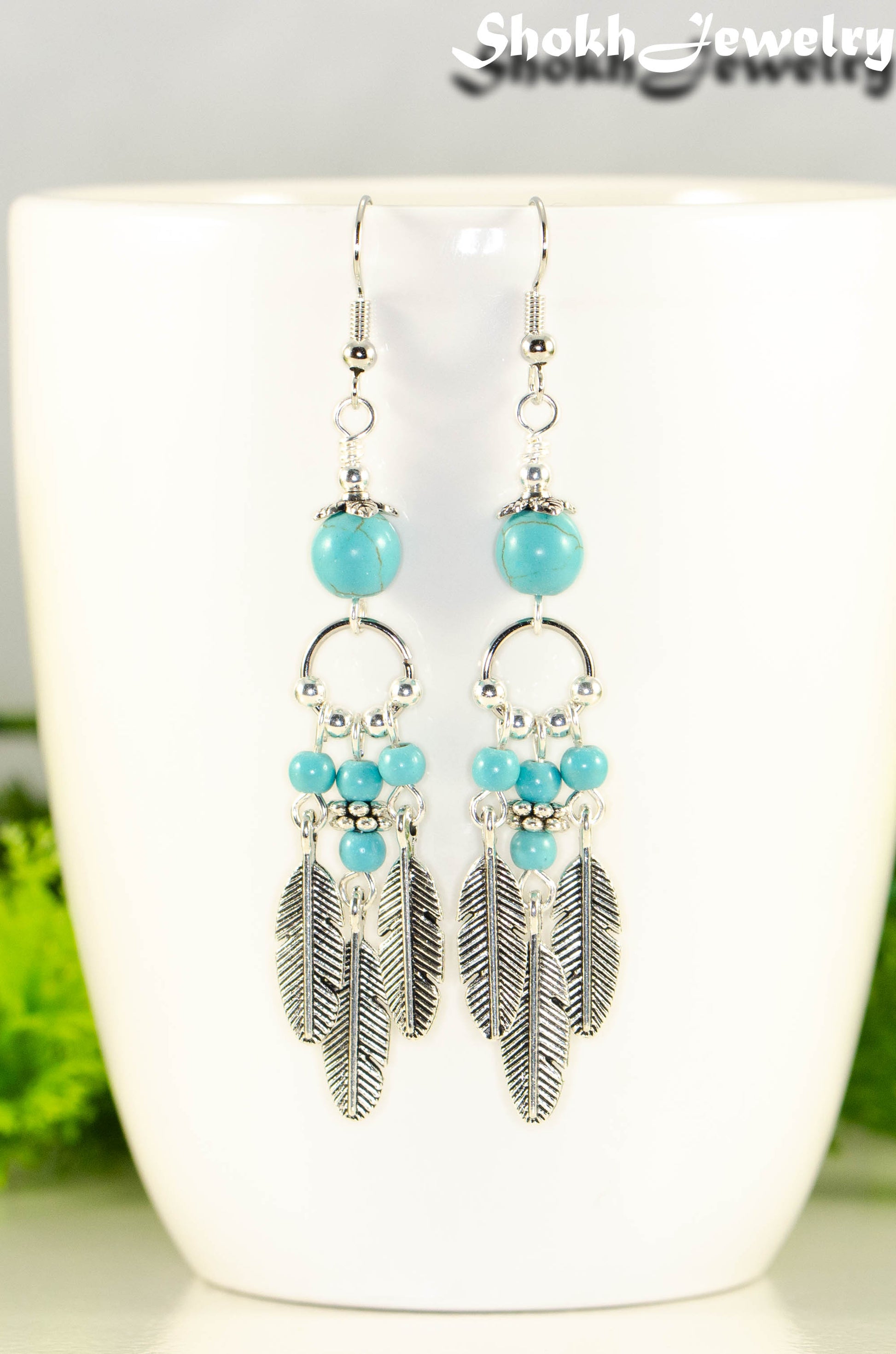 Close up of Statement Turquoise Howlite And Feather Earrings.