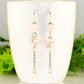 Long Stainless Steel Chain and Rose Quartz Earrings displayed on a coffee mug.