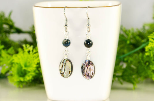 Long Oval Abalone Shell Earrings displayed on a tea cup.